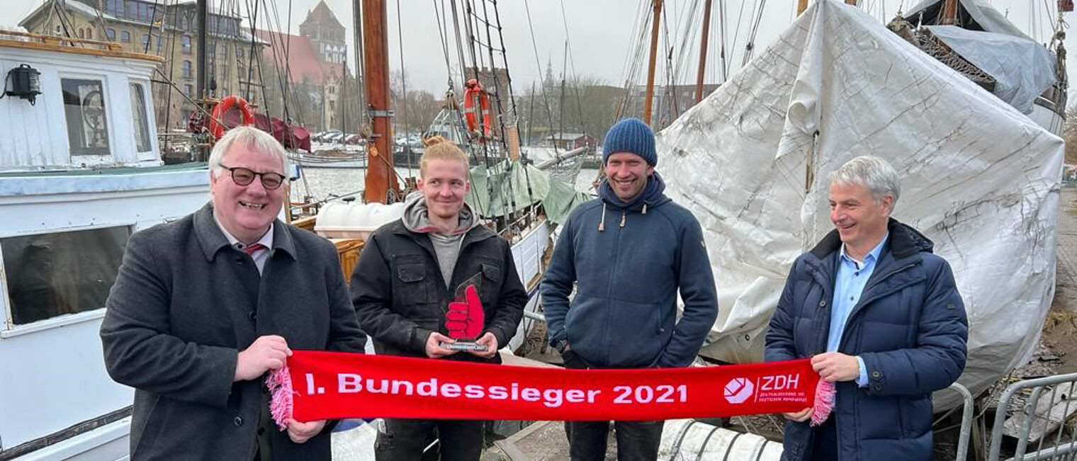 Axel Hochschild (Präsident der HWK OM-V), Bootsbauer Florian Woll (1. Bundessieger), Bootsbaumeister Karsten Burwitz (Ausbildungsbetrieb), Jens-Uwe Hopf (Hauptgeschäftsführer der HWK OM-V)