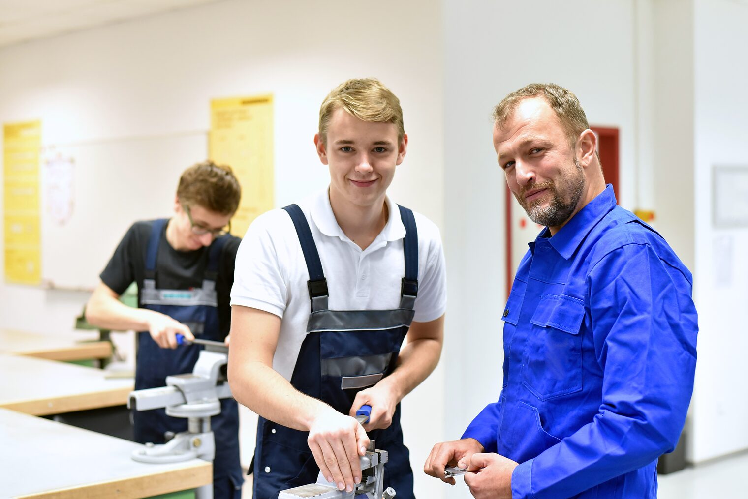 berufsausbildung, azubi, ausbildung, handwerk, industrie, mann, personen, jugendlicher, berufsbildung, auszubildenter, beruf, arbeiten, gruppe, arbeitsplatz, kaukasier, jung, arbeitskleidung, lächeln, fröhlichkeit, lachen, professionell, ausbilden, meister, schüler, lehrling, schule, training, lehren, jugendliche, schraubstock, praxis, praktisch, nachwuchs, karriere, berufsschule, bildung, ausbilder, lehrer, azubis, vor ort, qualifizierung, qualifiziert, tätigkeit, metallbau, stahlbau, werkstück, bauteil, berufsbekleidung, werkstatt, werkstätte